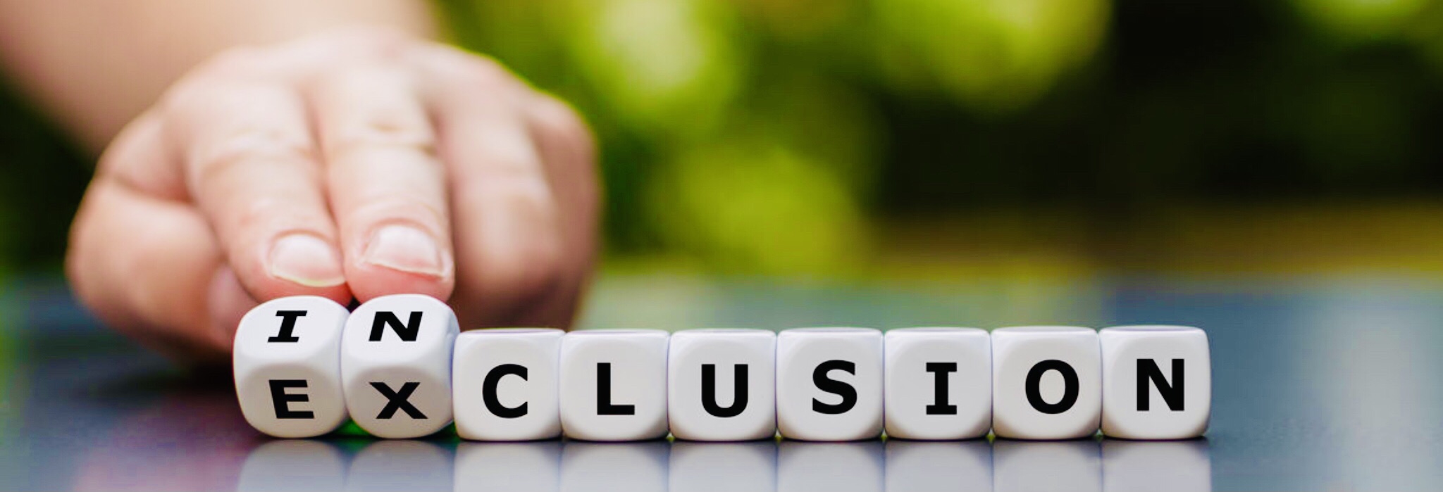 Een hand die het woord exclusion verandert in inclusion.
